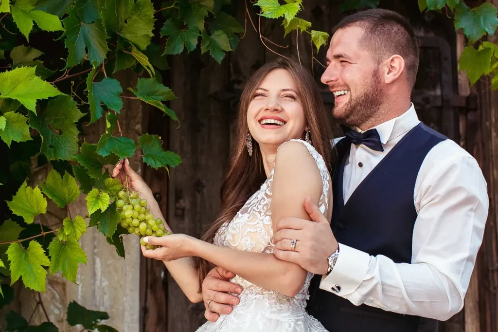 Портрет наречених, що сміються, весільна фотосесія з виноградом, емоційна зйомка у Львові, професійний фотограф RoStudio.