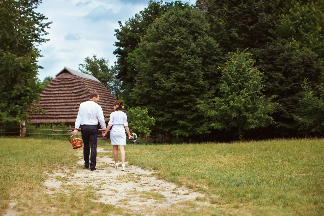 фотосесія лав сторі Львів, пара у вишиванках йде по дорозі, професійний фотограф, відеозйомка весілля Львів, ціна, кошик для пікніка
