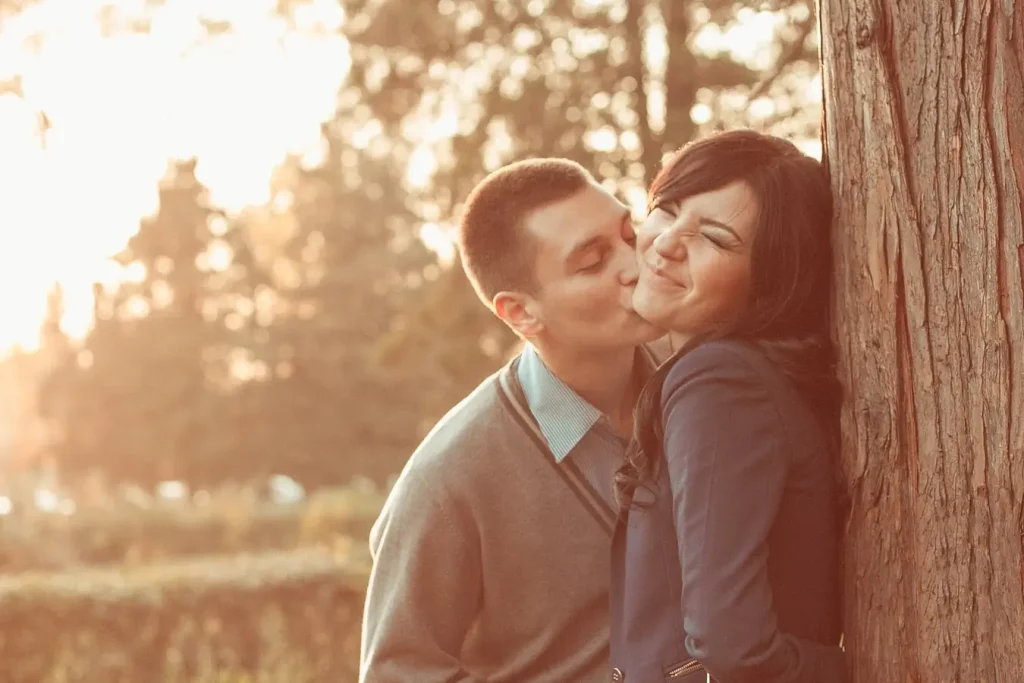 фотосесія лав сторі Львів, пара в осінньому парку, чоловік цілує дівчину в щоку, професійна зйомка, ціна послуг, найкращий фотограф Львів