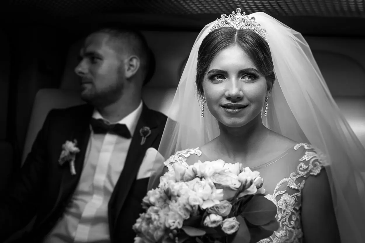 Чорно-біле фото нареченої з букетом у лімузині, класичний весільний портрет, професійна фотосесія у Львові, весільний фотограф та відеограф RoStudio.