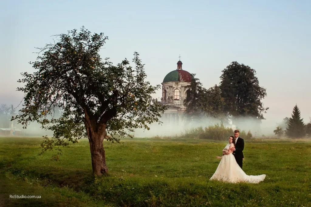 Весільна фотосесія біля костелу в Підгірцях, молодята в тумані, послуги фотографа Львів, професійна відеозйомка ціна, виїзна зйомка.