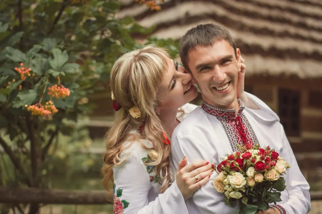 весільна фотосесія Львів, професійний фотограф, відеозйомка весілля Львів, пара у вишиванках з букетом троянд, ціна послуг