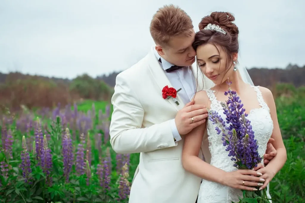 Молодята в обіймах серед поля люпинів, ніжний весільний портрет, професійна зйомка у Львові від RoStudio.
